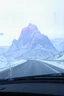 Placeholder: surreal purple plastic mountain road seen through a dirty truck front window, dirty blue snow and wind