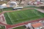 Placeholder: Cândido de Oliveira" Football Stadium, an aerial photograph taken by a drone in a futuristic landscape in an abandoned Alentejo village with white neon light, Shot on Canon EOS R5, 50mm lens, depth of field, shutter speed 1/ 1000, f/ 2. 8, white balance, 6000k. High resolution, realistic details, HDR efects, film grain, 4K. –ar 16: 10 –