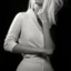 Placeholder: Mujer rubia iluminada, retrato medio cuerpo, iluminada potentemente desde el lado derecho, blanco y negro vaporoso, peinado a lo Verónica Lake al estilo del fotógrafo Hugo Alonso