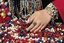 Placeholder: close-up high res photo by russ meyer: a gypsy's wrist surrounded and saturated by strings of pearls, the hundreds of pearls in every color shaped like dice or skulls. It's the childlike, mortal symbol of chance intertwined with destiny.
