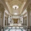 Placeholder: opulent and luxurious pale seafoam and white color mediterranean revival style hall; view from the huge central hall looking up at the building