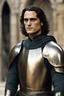 Placeholder: Joaquin Phoenix from year 2000, draped waves haircut, black hair, in medieval setting, in burnished medieval armor