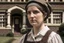 Placeholder: ww1 maid talking close-up standing up looking to the camera, ww1 mansion quarters background