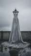Placeholder: A wet washed wedding dress hanging on a rob in a stormy foggy sky in the background