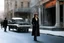 Placeholder: (photo from a movie by Quentin Tarantino) a woman detective investigates a strange case on ghosts killing people because a road perturbated their old HQ... She is standing on the sidewalk