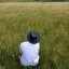 Placeholder: man with a panama hat reflects sitting in a meadow