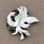 Placeholder: phoenix ivory brooch against black velvet, opalescent marble carving, decorative design, classical ornament, highly ornate, highly intricate, highly detailed etching, marble carving, warm lighting