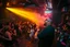 Placeholder: dans golv på en nedsliten sunkig techno club, många personer som dansar, yppiga kvinnor, mycket scen rök i lokalen, och gula röda strobes, en del personer ser in i kameran och skriker: "Benny!" och en Neon Skylt med texten "DJ ROY" på väggen, DJ Roy skriker rätt in i kameran, öppen mun, mycket flaskor och glas i baren