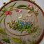 Placeholder: exquisite whimsical garden in embroidery hoop, intricate, highly detailed, linen and wood backdrop