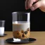 Placeholder: Pour milk into a clear glass cup. Inside the cup is a whole cookie.