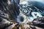 Placeholder: at the base of the rocky mountain peninsula, a great whirlpool waterfalls into deeper unknown depths