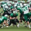 Placeholder: Boston Shamrocks Football team playing against the Toronto Rifles Football team,vintage, hyper-realistic, in color, Boston in green, Toronto in Red