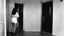 Placeholder: [photo by Russ Meyer, in the 90ties] facing a lonely smiling woman on the door step of an appartement, in gym, talking. we see the corridor behind her