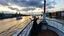 Placeholder: UK oxford street over times river, on wide deck of a big moving ship beautiful lady dancing ,ships in river, cloudy sky,sunset,golden sky