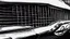 Placeholder: Photograph of a the front grill of a gorgeous, expensive, oldschool black muscle car with a big, black front grill, realistic, stylish, taken up close, symmetrical