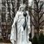 Placeholder: photo of a lady statue made of white marbel with black parts showing a goddoss love in a modern city center park