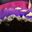 Placeholder: Claymation mountain skyline,Rudolph the red noise reindeer, beautiful, pastel blues and purples, white, aurealis borealis, night, claymation moon, clouds, stars, winter