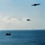 Placeholder: the jump over the strait of Ormuz with one gun in each hand iconic scene by John Woo (A Better Tomorrow, The Killer, Hard-Boiled) There's a frigate in the background
