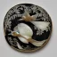 Placeholder: coaster of kingfisher ivory brooch with black pearl inlay, opalescent marble carving, decorative design, classical ornament, highly ornate, highly intricate, highly detailed etching, marble carving, warm lighting, linen backdrop