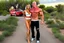 Placeholder: make a pic with short hair bald bodybuilder Knut Spildrejorde from Norway and his fitness wife Jeanette, they are standing front of his new red car Chevrolet Camaro, very busy highway in sunny desert Texas in the background