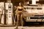 Placeholder: beautiful vintage photography with sepia tones, woman in tight jeans and a crop top pumping gas at a rustic country gas station, long shot, hyper detailed, trending on artstation, intricate details, highly detailed