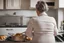 Placeholder: back view of mature woman cooking