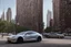 Placeholder: A Tesla 'Model Y' is parked, near the Flatiron Building in Manhattan. (CINEMATIC, WIDE ANGLE LENS, PHOTO REAL)