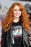 Placeholder: Debby Ryan, smiling, Heavy Metal t-shirt, Black Leather biker's jacket, midday, bright sunlight, extremely colorful. Big, fluffy hair, Debby Ryan has Auburn Red hair, green eyes,