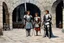Placeholder: [middle age art by Jason and the Argonauts (1963)] at nightfall: lonely youthful smiling Joan of arc in her armour in the courtyard of the Royal Court in Chinon for an audience with Charles, the King of France at the age of 17. the guards open the gates of the city