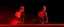 Placeholder: 2 horses running towards the viewer but opposite sides, mostly red tones on dark background