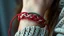 Placeholder: very close-up photo of a bracelet made of red-white-green yarn on a woman's wrist, detailed, sharp contrasts, realistic, cinematic, blur background