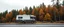 Placeholder: A camping bus at the side of a road, facing towards a cozy forest scenery using this color scheme: base00: "2f383e" # bg0, palette1 dark (medium) base01: "374247" # bg1, palette1 dark (medium) base02: "4a555b" # bg3, palette1 dark (medium) base03: "859289" # grey1, palette2 dark base04: "9da9a0" # grey2, palette2 dark base05: "d3c6aa" # fg, palette2 dark base06: "e4e1cd" # bg3, palette1 light (medium) base07: "fdf6e3" # bg0, palette1 light (medium) base08: "7fbbb3" # blue, palette2 dark base09: