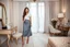 Placeholder: very beautiful sexy lady with beautful gray midi skirt and blouse standing in a luxury bedroom with high heels next to makeup desk looking to camera