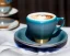 Placeholder: Cappuccino art microfoam in teal cup saucer Crawford plaid napkin Demitasse