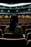 Placeholder: From the side, A person in a movie theatre looking at the camera beside them