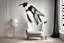 Placeholder: penguin shaped and penguin coloured (black and white) armchair in a modern room, with human feet decorated wallpaper in the background in sunshine