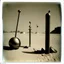 Placeholder: Odd spindle-shaped objects scattered over an arid surface, nothingness, polaroid, in Yves Tanguy style