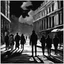 Placeholder: woman in the midle of a peatonal walk in e great city; behind her, unfocaused, other people walking, realism, black and white