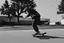 Placeholder: a black and white photo of a man on a skateboard in front of a, inspired by Jens Søndergaard, a screenshot, featured on dribble, digital screenshot, dutch camera view, chasing a robber down a street, screenshots, video, still from a music video, odd, unsettling, absurd, glitch deconstruction