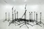 Placeholder: A pile of microphone stands in an empty white room