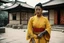 Placeholder: [very impressive high res masterpiece in Kodak Eastman 5247, bokeh scene by Stanley Kubrick] woman Shaolin gangsta monk covered by tattoos waiting outside in yellow kimono, on a stone doorstep, she menaces the camera with her finger