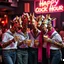 Placeholder: very Gay Giraffes sailors with white shirts and berets and tight jeans standing in a bar drinking drinks with umbrellas, pride, makeup, smoking cigaretts, smiling, sparkling eyes, very happy, after dark, pink scarf, happy hour drinks neon signs, necking, happy cock hour, pride, pride and pride