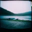 Placeholder: A polaroid photo of an odd room with structures. A transparent tarpaulin covers an image. There is a group of fir trees in the background and a high hill in the distance. A lake. The surface below is in a pastel color. Fog is present.