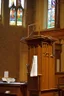 Placeholder: The Bible lies on the pulpit in the church hall, and above it are several question marks