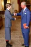 Placeholder: The Prince of Wales in traditional dress shakes hands with a young guest dressed in a blue suit, drawing room of St James's Palace, during a reception