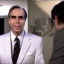 Placeholder: Tom Snyder in a suit leaning forward to talk to someone, 80's television screengrab