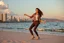 Placeholder: beautiful lady with makeup in pants and pretty shirt curvy long hair sport shoes dancing in sea side over soft sands ,modern city escape at dintant ,pretty clouds, golden hour