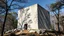 Placeholder: Amid the whispering trees, a majestic block of brutalist architecture rises with an aura of serene strength. The concrete structure stands solemnly, a sanctuary of rocks and silence in its surroundings. This stunning photograph captures the stark beauty of the building contrasting with the natural landscape. Shadows play across the rough surfaces, highlighting the raw honesty of the materials. The image portrays a perfect harmony between man-made creation and the ethereal beauty of nature, creat