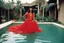 Placeholder: [photo by helmut newton] 70ties light red dress revealing Latina woman blunt bangs, in the hacienda of a drug dealer, sits in a swimming pool, wet fabric