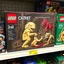 Placeholder: In Situ Photograph of a Lego box displayed on a toy store shelf titled "Saturn Devouring his SON", Lego interpretation of Francisco Goya iconic 'Saturn devouring his son' painting, the scene recreated using legos snapped together, uncanny, faded colors, Mad Titan Cronos, Lego creation with raised lego pips,